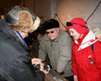 Steffen Bo Hansen, drill mechanic at the NEEM drill site, shows the deep ice core drill to the royal couple.